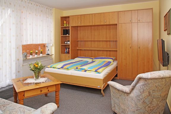 Wohnzimmer mit Schrankbett, bietet zusätzliche Schlafmöglichkeit für 2 Personen